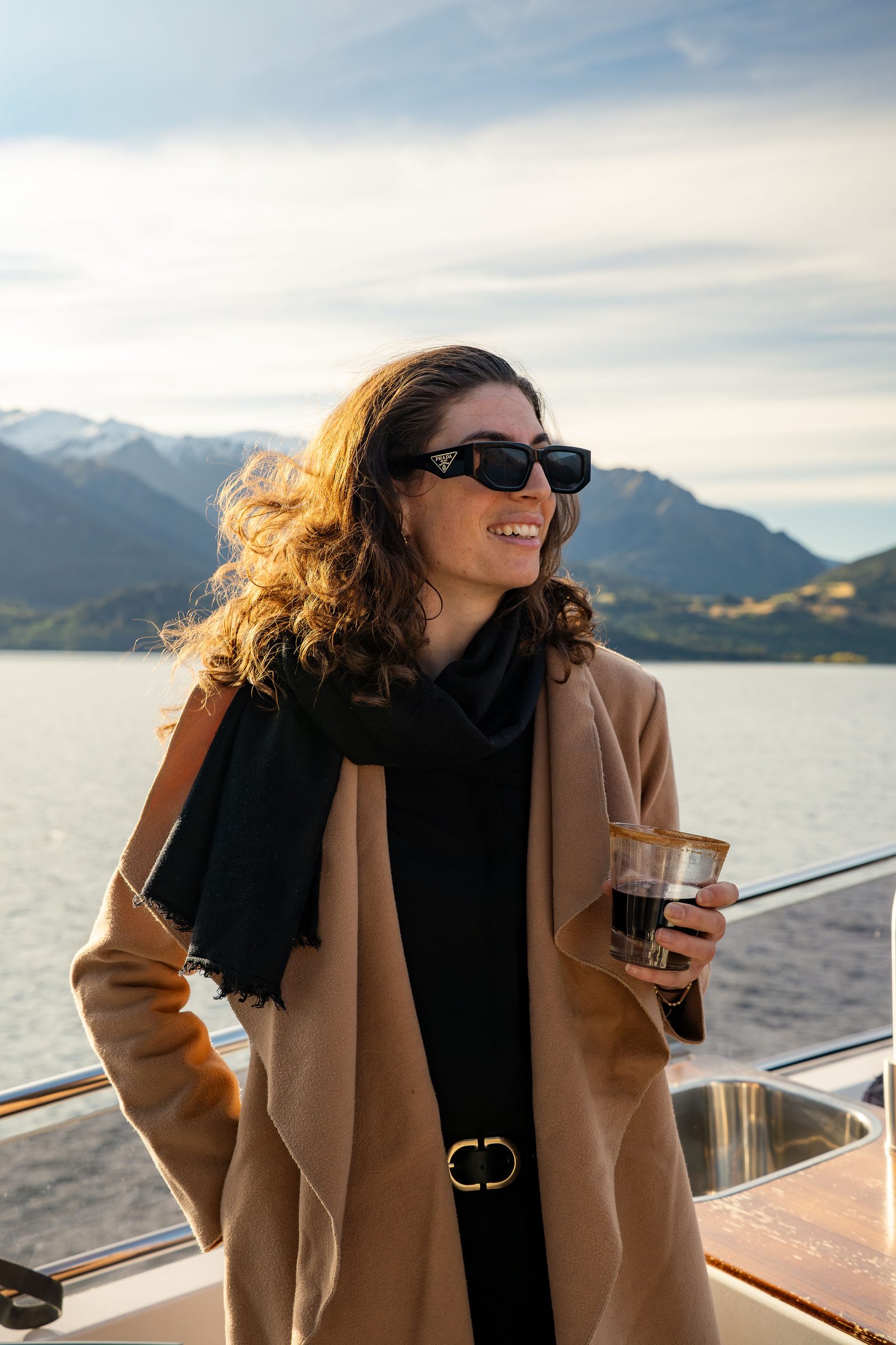 A guest with mulled wine in hand on Lake Wakatipu